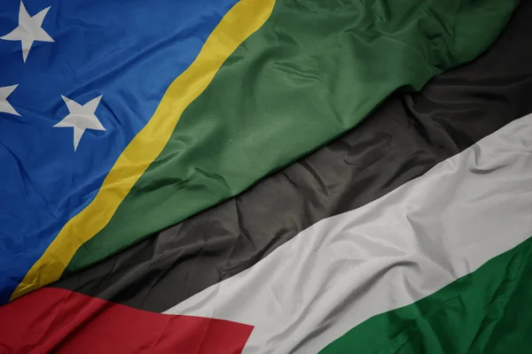 waving colorful flag of palestine and national flag of Solomon Islands .