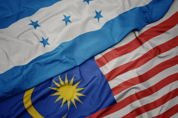 Размахивая красочным флагом Малайзии и национальным флагом Гондураса . — стоковое фото