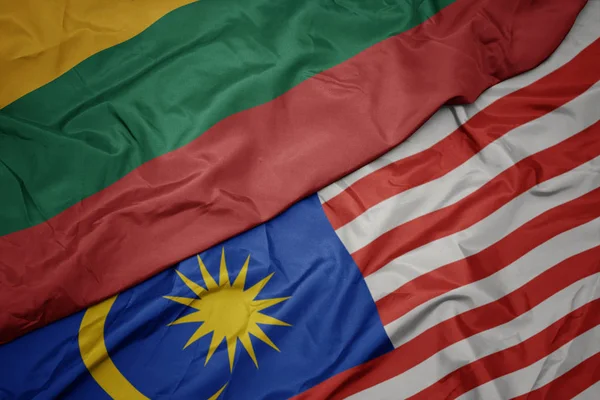 Waving colorful flag of malaysia and national flag of lithuania. — Stock Photo, Image
