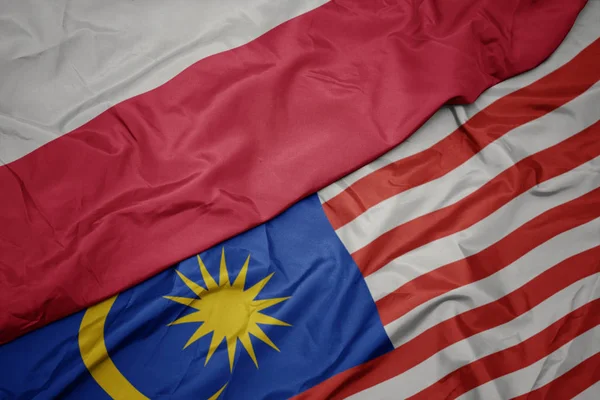 Sventolando bandiera colorata della Malesia e bandiera nazionale della Polonia . — Foto Stock