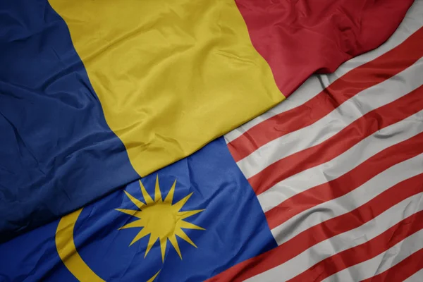 Sventolando bandiera colorata della Malesia e bandiera nazionale della Romania . — Foto Stock