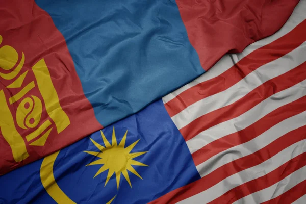 Sventolando bandiera colorata della malesia e bandiera nazionale della mongolia . — Foto Stock