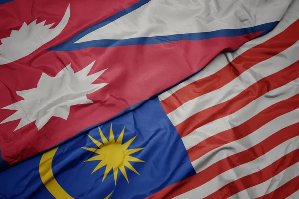 Zwaaiende kleurrijke vlag van Maleisië en de nationale vlag van Nepal. — Stockfoto