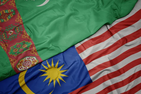 Sventolando bandiera colorata della Malesia e bandiera nazionale del turkmenistan . — Foto Stock