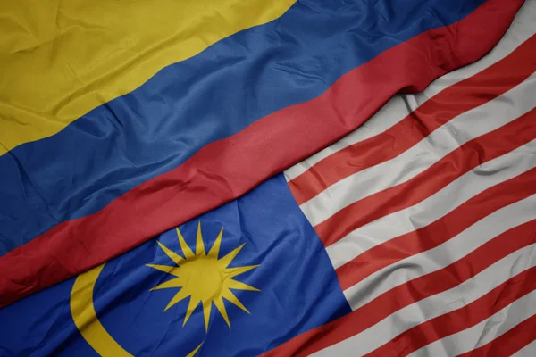 Schwenken bunte malaysische Flagge und kolumbianische Nationalflagge. — Stockfoto