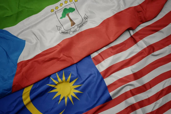 Размахивая красочным флагом Малайзии и национальным флагом Экваториальной Гвинеи . — стоковое фото