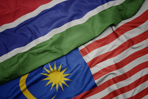 Размахивая красочным флагом Малайзии и национальным флагом Гамбии . — стоковое фото