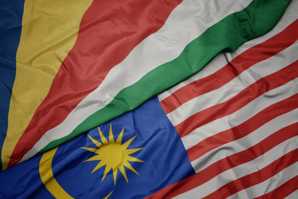 Размахивая красочным флагом Малайзии и национальным флагом сейшельских островов . — стоковое фото