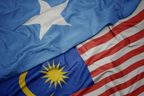 Waving colorful flag of malaysia and national flag of somalia. — Stock Photo, Image