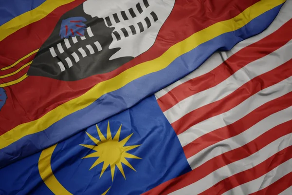 挥舞着五颜六色的马来西亚国旗和斯威士兰国旗. — 图库照片