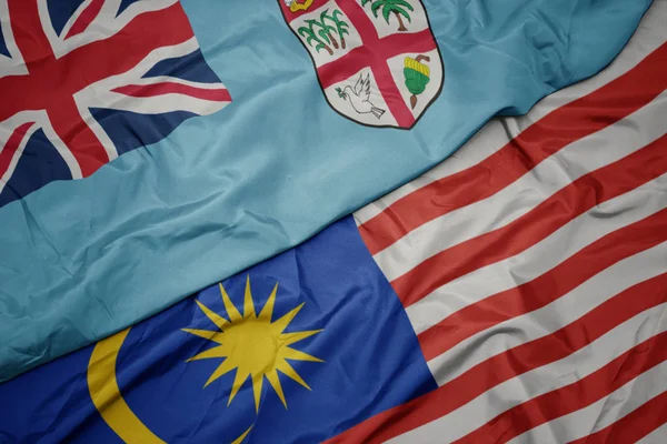 Размахивая красочным флагом Малайзии и национальным флагом Фиджи  . — стоковое фото