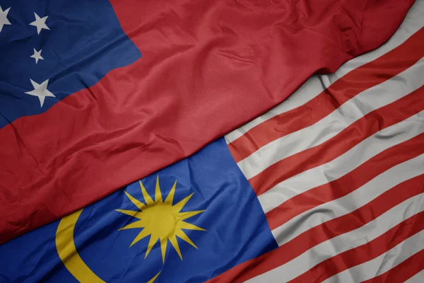 Schwenken bunte Flagge von Malaysia und Nationalflagge von Samoa . — Stockfoto