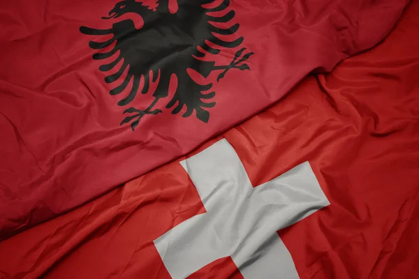 İsviçre ve arnavutluk ulusal bayrağı renkli bayrak sallayarak. — Stok fotoğraf
