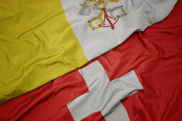 Sventolando bandiera colorata della Svizzera e bandiera nazionale della città vaticana . — Foto Stock