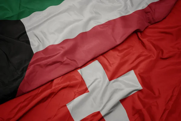 Acenando bandeira colorida da Suíça e bandeira nacional do kuwait . — Fotografia de Stock