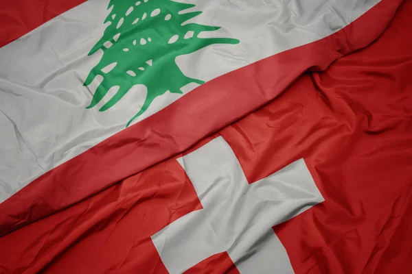 Waving colorful flag of switzerland and national flag of lebanon. — Stock Photo, Image