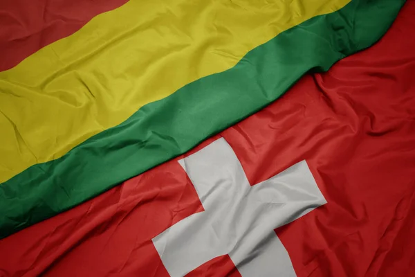 Розмахуючи барвистий прапор Швейцарії та державного прапора Болівії. — стокове фото