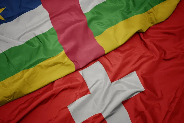 Vifta färgglada flagga Schweiz och nationella flaggan i Centralafrikanska republiken. — Stockfoto