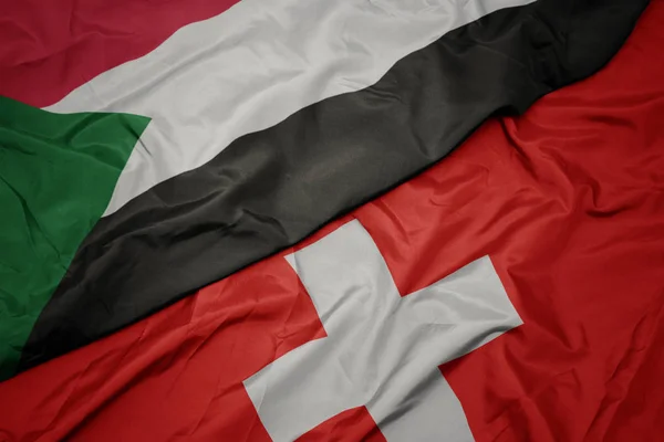 A svájci zászló és Szudán nemzeti zászló színpompás zászlója. — Stock Fotó