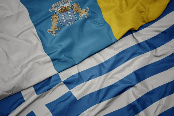 Mávající barevná vlajka Řecka a národní vlajka Kanárských ostrovů. — Stock fotografie