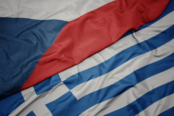 Zwaaiende kleurrijke vlag van Griekenland en de nationale vlag van Tsjechië. — Stockfoto