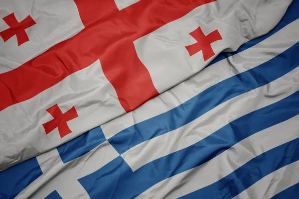 Mávající barevná vlajka Řecka a národní vlajka Gruzie. — Stock fotografie