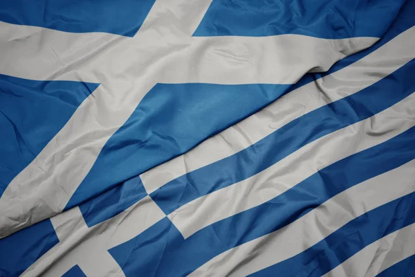 Ondeando colorida bandera de Grecia y bandera nacional de Escocia . — Foto de Stock