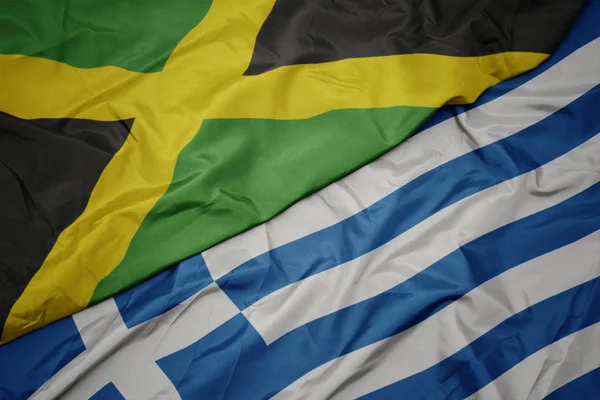 Schwenken bunte Flagge von Griechenland und Nationalflagge von Jamaica. — Stockfoto