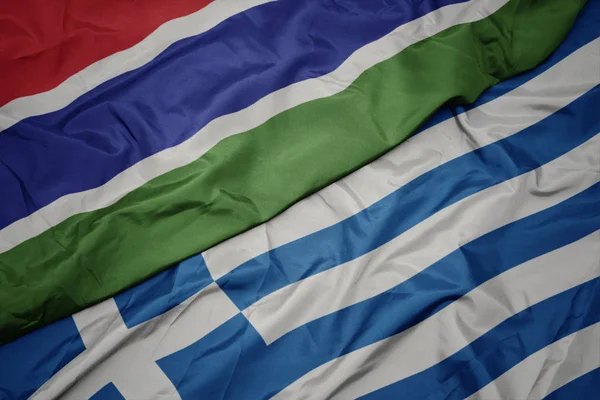 Acenando bandeira colorida da Grécia e bandeira nacional da Gâmbia . — Fotografia de Stock