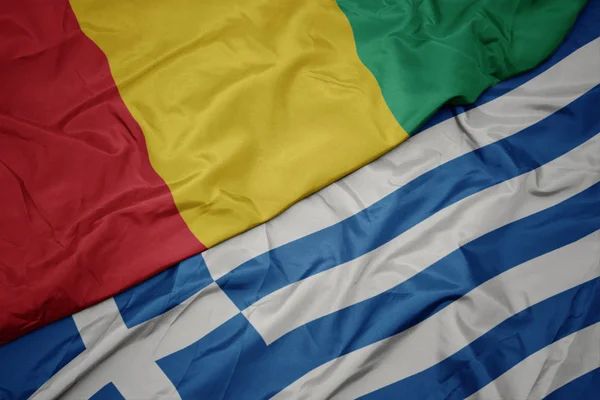 Acenando bandeira colorida da grécia e bandeira nacional da Guiné . — Fotografia de Stock