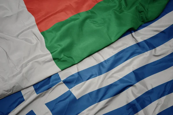 Waving colorful flag of greece and national flag of madagascar. — Stock Photo, Image