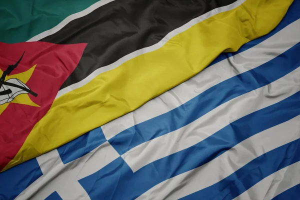 Mávající barevná vlajka Řecka a národní vlajka Mosambiku. — Stock fotografie