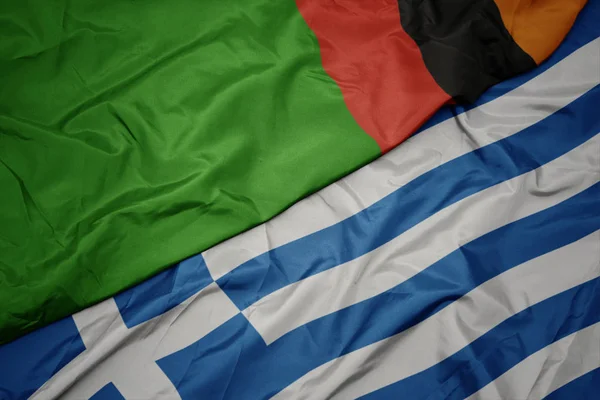 Waving colorful flag of greece and national flag of zambia. — Stock Photo, Image