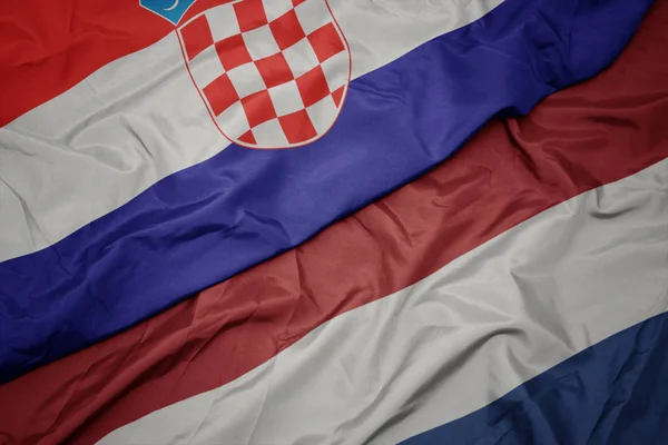 Ondeando colorida bandera de los Países Bajos y bandera nacional de croacia . —  Fotos de Stock
