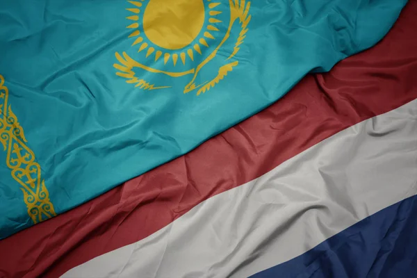 Hollanda ve kazakistan ulusal bayrağı renkli bayrak sallayarak. — Stok fotoğraf