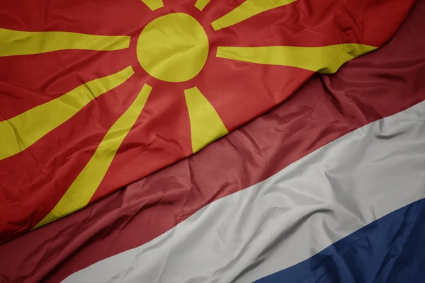 Fluturând steagul colorat al teritoriilor de jos și drapelul național al macedoniei . — Fotografie, imagine de stoc