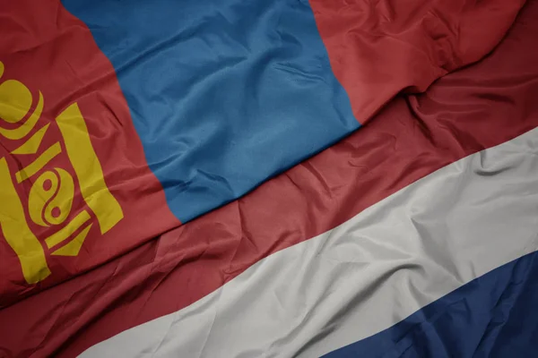 Mávající barevná vlajka Nizozemska a národní vlajky Mongolska. — Stock fotografie