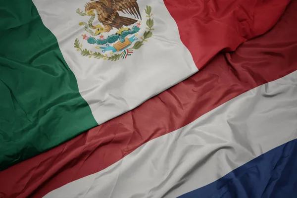 Waving colorful flag of netherlands and national flag of mexico. — Stock Photo, Image