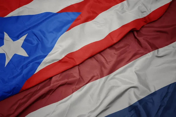 Falujące kolorowy flaga Holandii i flagi narodowej Puerto Rico. — Zdjęcie stockowe