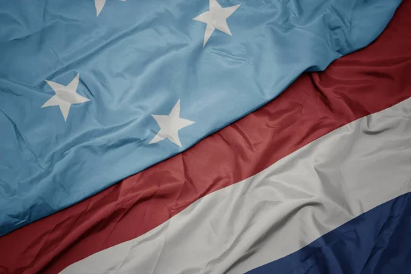 Waving colorful flag of netherlands and national flag of Federated States of Micronesia . — Stock Photo, Image