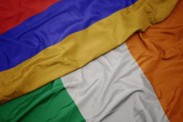 Waving colorful flag of ireland and national flag of armenia. — Stock Photo, Image