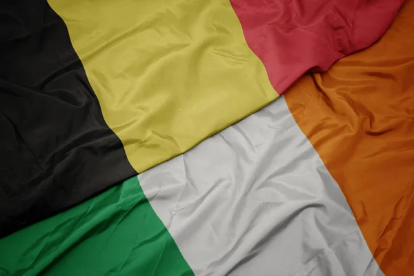 Waving colorful flag of ireland and national flag of belgium. — Stock Photo, Image