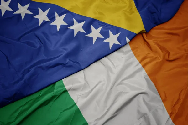 Acenando bandeira colorida da Irlanda e bandeira nacional da Bósnia e Herzegovina . — Fotografia de Stock