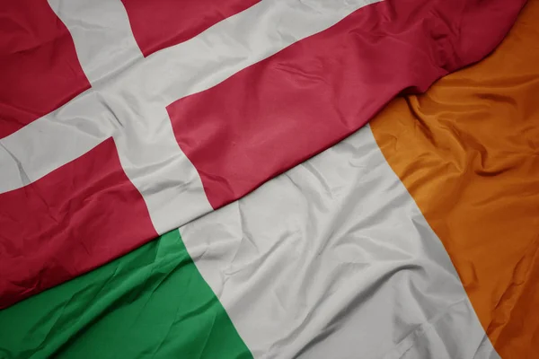 Sventolando bandiera colorata dell'Irlanda e bandiera nazionale di denmark . — Foto Stock