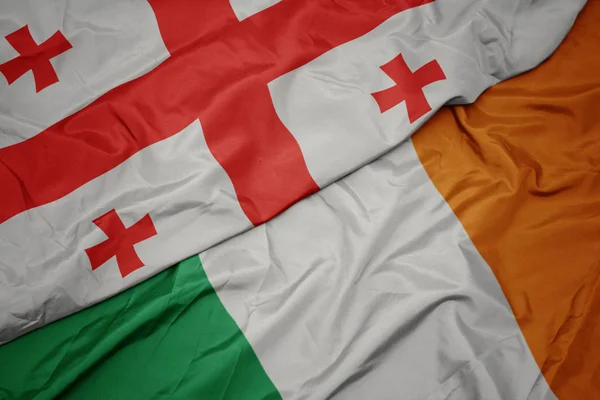 아일랜드의 화려한 국기와 조지아의 국기를 흔들기. — 스톡 사진