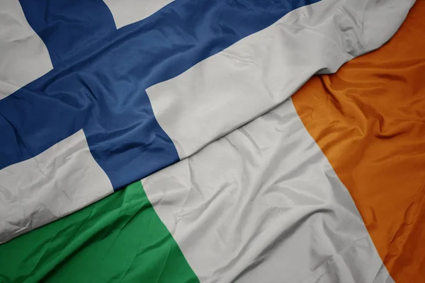 Falujące kolorowe flagi Irlandii i flagi narodowej Finlandii. — Zdjęcie stockowe