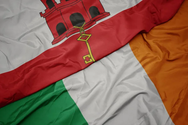 Falujące kolorowe flagi Irlandii i flagi narodowej Gibraltaru. — Zdjęcie stockowe