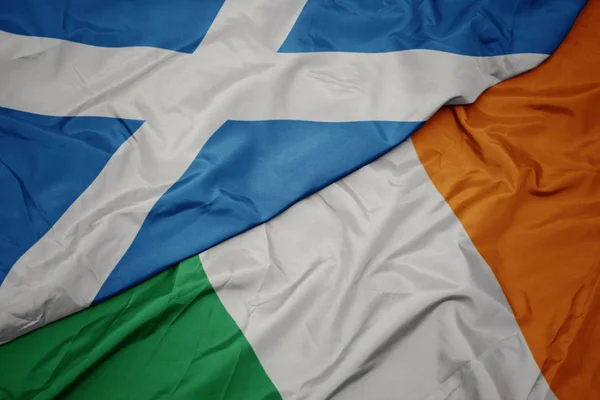 Acenando bandeira colorida da Irlanda e bandeira nacional da Escócia . — Fotografia de Stock