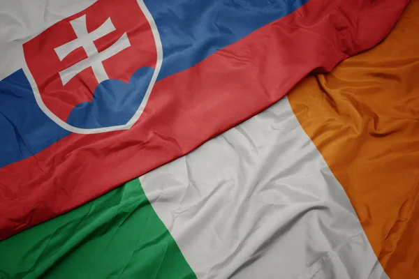 Waving colorful flag of ireland and national flag of slovakia. — Stock Photo, Image