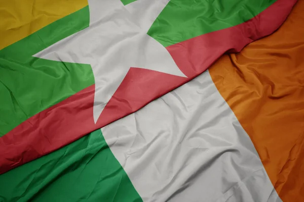 Schwenken bunte Flagge Irlands und Nationalflagge von Myanmar. — Stockfoto